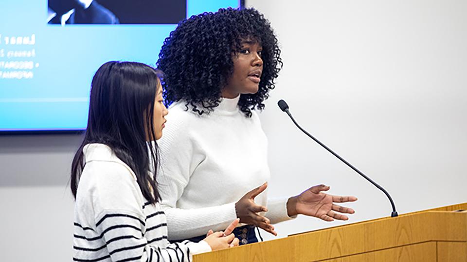 Two students giving a presentation at a podium