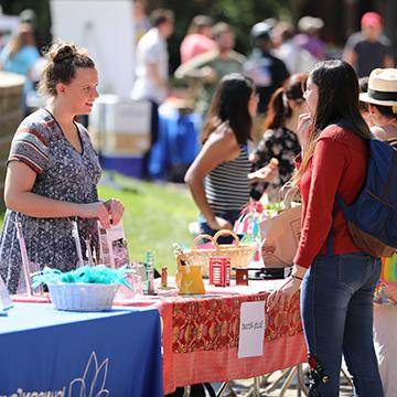 A student chats with a staff member about study abroad opportunities during the student involvement fair.